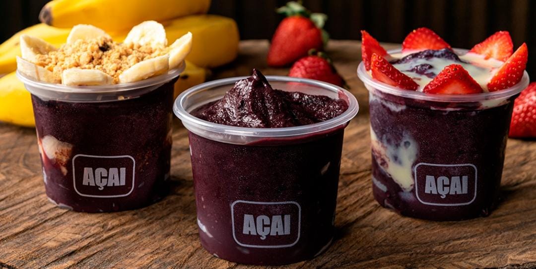 Três copos de açaí com banana e granola, açaí puro e morangos com leite condensado